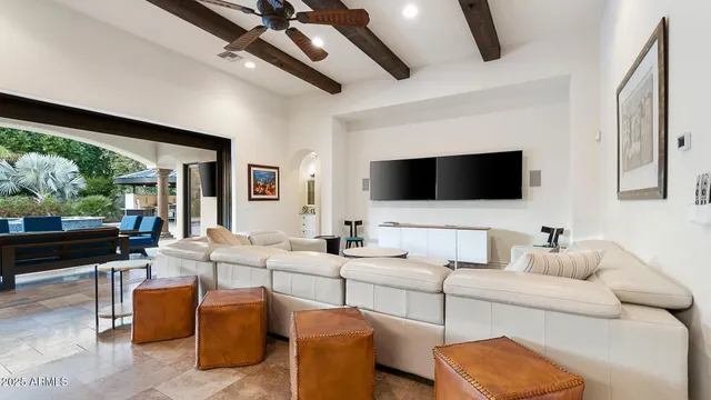 a living room with furniture a flat screen tv and a floor to ceiling window