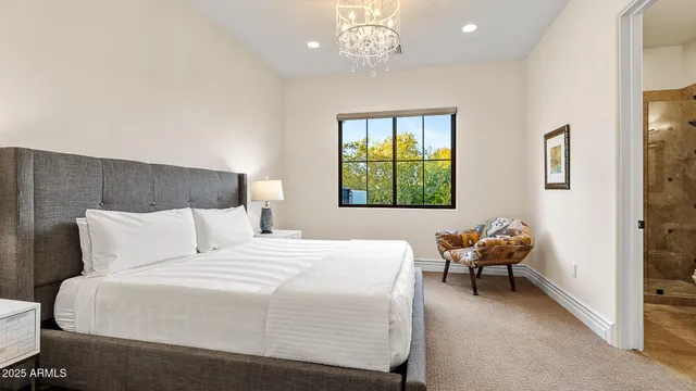 a bedroom with a bed and a chandelier