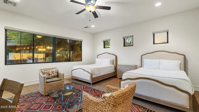 a bedroom with furniture and a large window