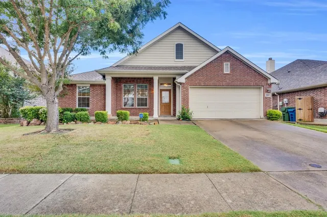 a front view of a house with a yard and potted plants