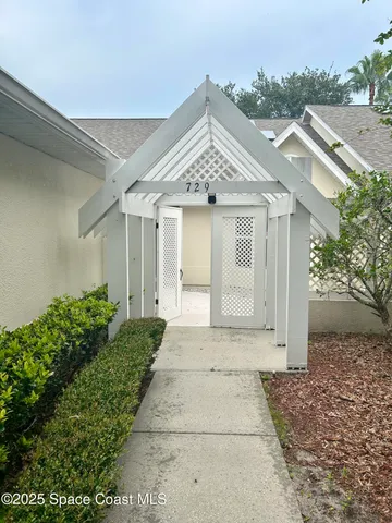 a view of a white house next to a yard