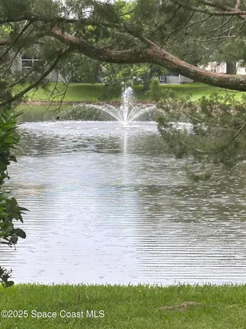 a large white kitchen with a stove a sink dishwasher and white cabinets with wooden floor