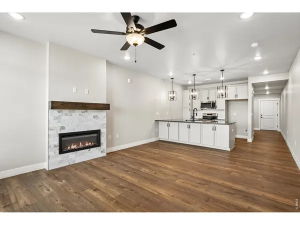 a view of kitchen and empty room with fireplace