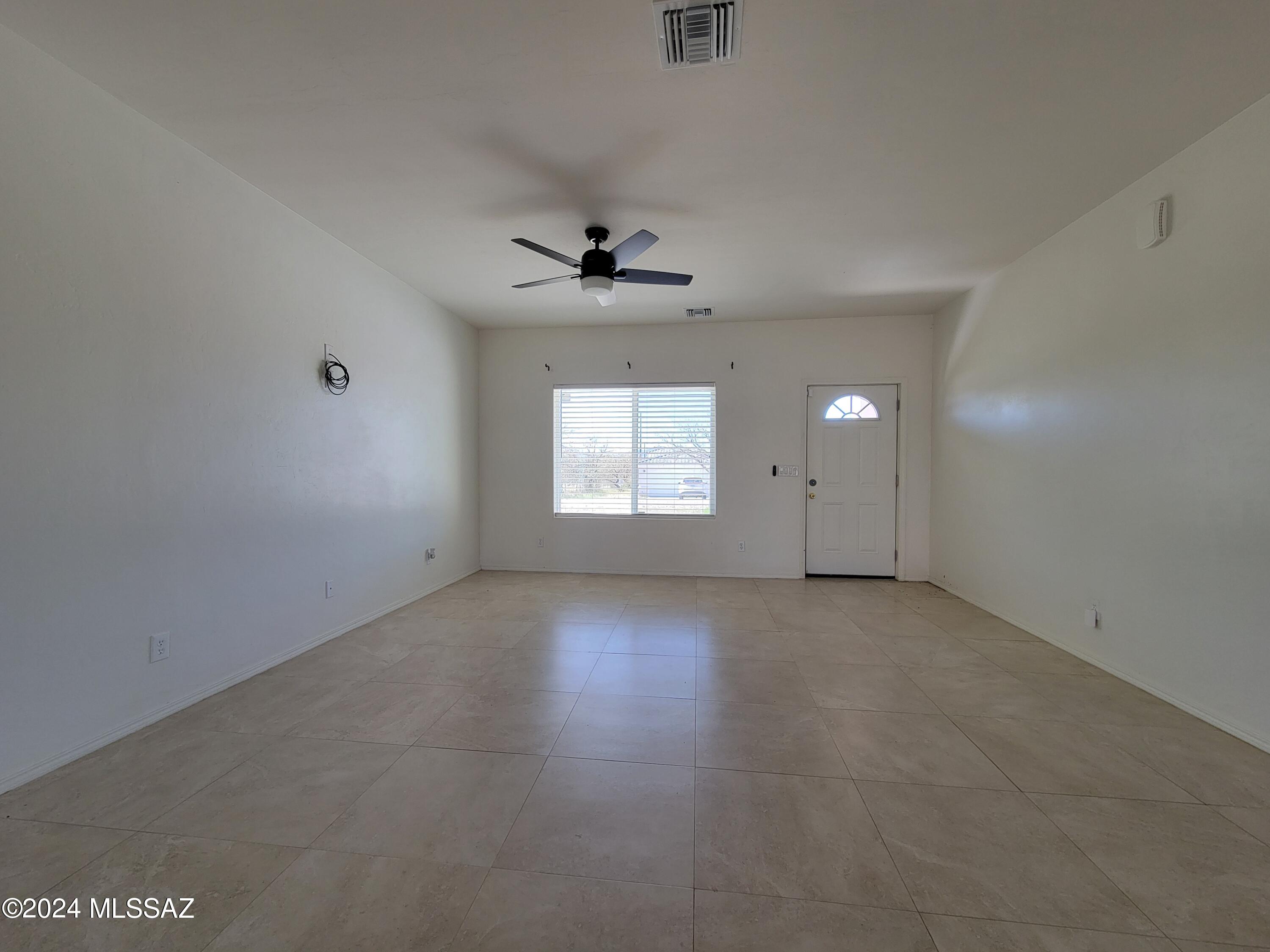 1763 Aguila Court Rio Rico, AZ 85648 - Photo 2 of 34 an empty room with a window and a ceiling fan