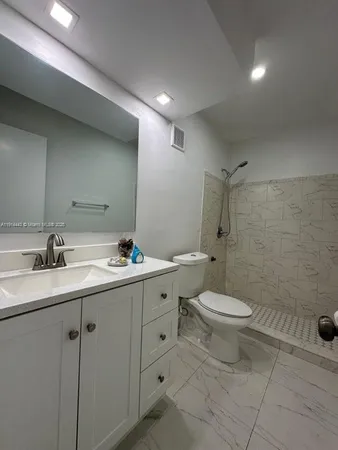 a bathroom with a toilet sink shower and mirror