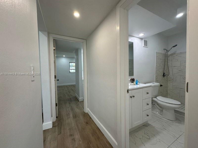 7610 Southwest 82nd Street, Unit J208 Miami, FL 33143 - Photo 12 of 13 a bathroom with a granite countertop toilet a sink and a mirror