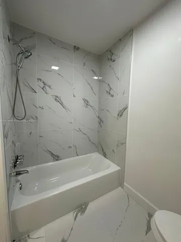 a bathroom with a bathtub and shower
