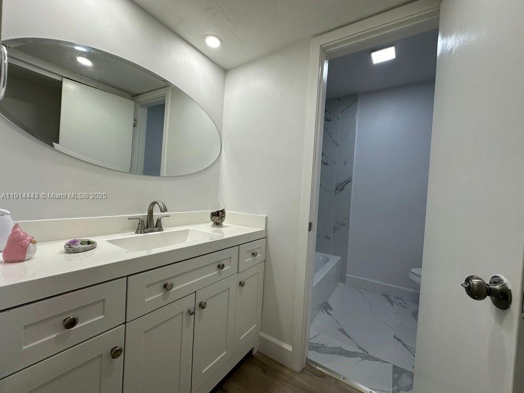 7610 Southwest 82nd Street, Unit J208 Miami, FL 33143 - Photo 7 of 13 a bathroom with a double vanity sink and mirror