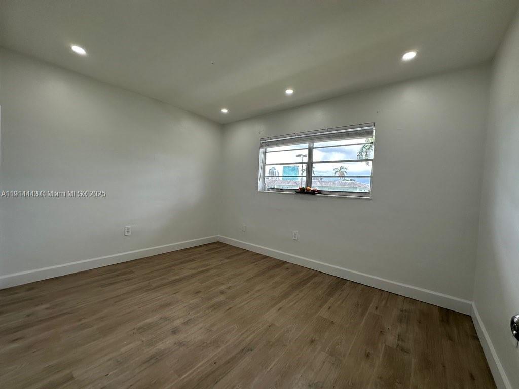 7610 Southwest 82nd Street, Unit J208 Miami, FL 33143 - Photo 10 of 13 an empty room with wooden floor and windows
