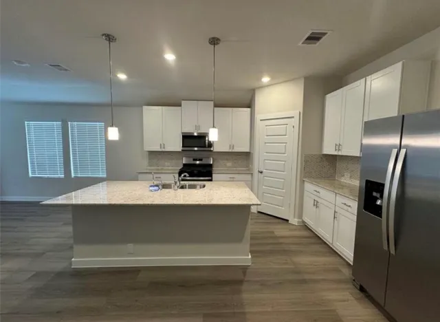 a kitchen with kitchen island sink refrigerator and stove