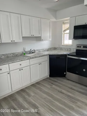 a kitchen with stainless steel appliances granite countertop a stove a sink and a microwave