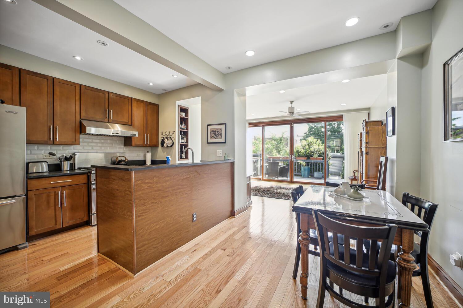 a kitchen with a table chairs refrigerator and microwave