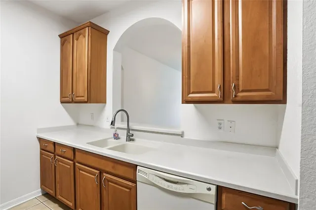 a view of an empty room and kitchen with a potted plant