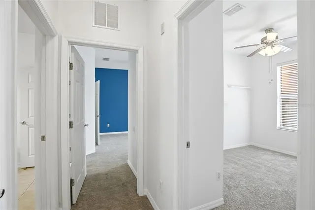 an empty room with a window and a fan