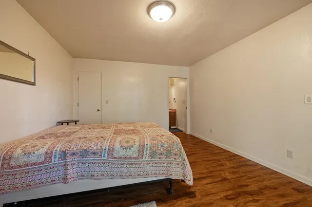 a bedroom with a bed and wooden floor
