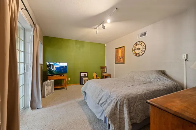 a bedroom with a bed and a view of kitchen