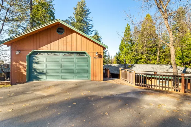 a view of backyard with large trees and wooden fence