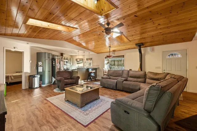 a kitchen with stainless steel appliances granite countertop a sink a stove and a wooden floors