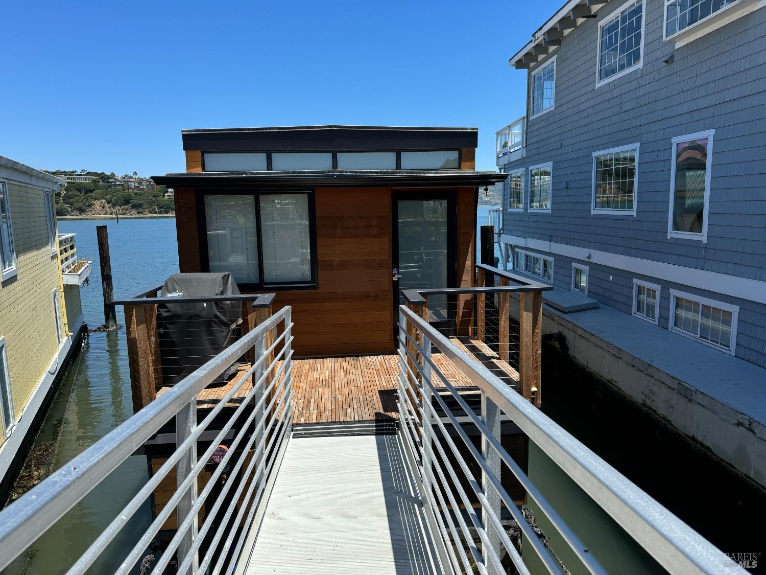 a view of a balcony with two chairs and a barbeque