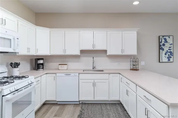 a kitchen with cabinets appliances a sink and a counter top space