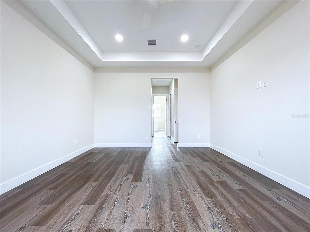 9065 Mississippi Run Weeki Wachee, FL 34613 - Photo 11 of 86 an empty room with wooden floor and windows