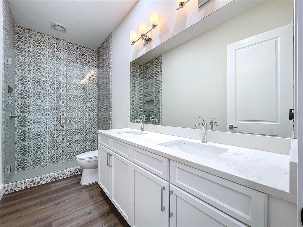 9065 Mississippi Run Weeki Wachee, FL 34613 - Photo 13 of 86 a bathroom with a granite countertop sink toilet and shower