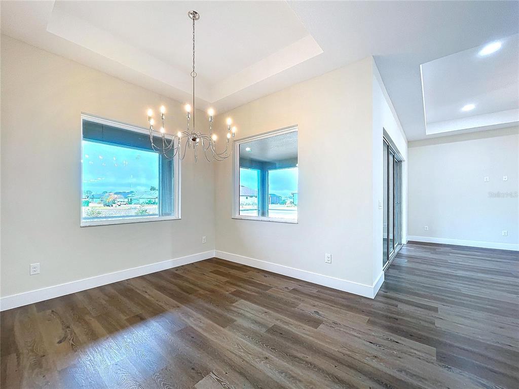 9065 Mississippi Run Weeki Wachee, FL 34613 - Photo 15 of 86 a view of a room with wooden floor chandelier and a window