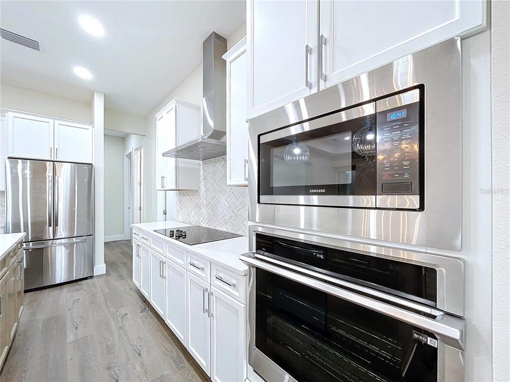 9065 Mississippi Run Weeki Wachee, FL 34613 - Photo 26 of 86 a kitchen with stainless steel appliances and granite countertop wooden cabinets