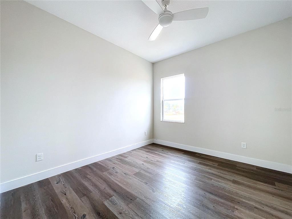 9065 Mississippi Run Weeki Wachee, FL 34613 - Photo 54 of 86 an empty room with wooden floor and windows