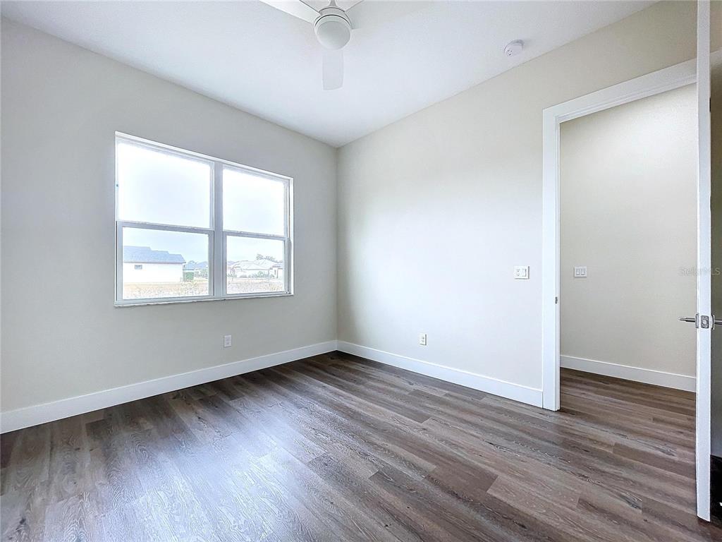 9065 Mississippi Run Weeki Wachee, FL 34613 - Photo 77 of 86 an empty room with wooden floor and windows