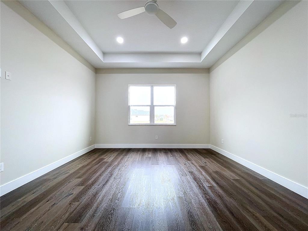 9065 Mississippi Run Weeki Wachee, FL 34613 - Photo 10 of 86 an empty room with wooden floor and windows