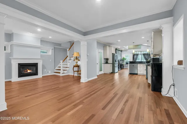 a view of a room with wooden floor and a kitchen