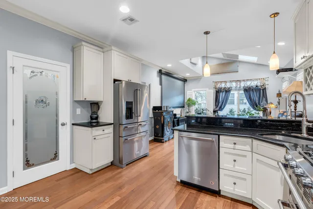 a kitchen with white cabinets and stainless steel appliances