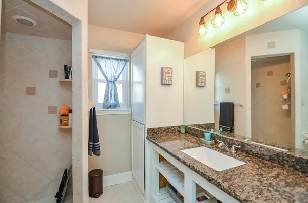 a bathroom with a granite countertop sink and a mirror