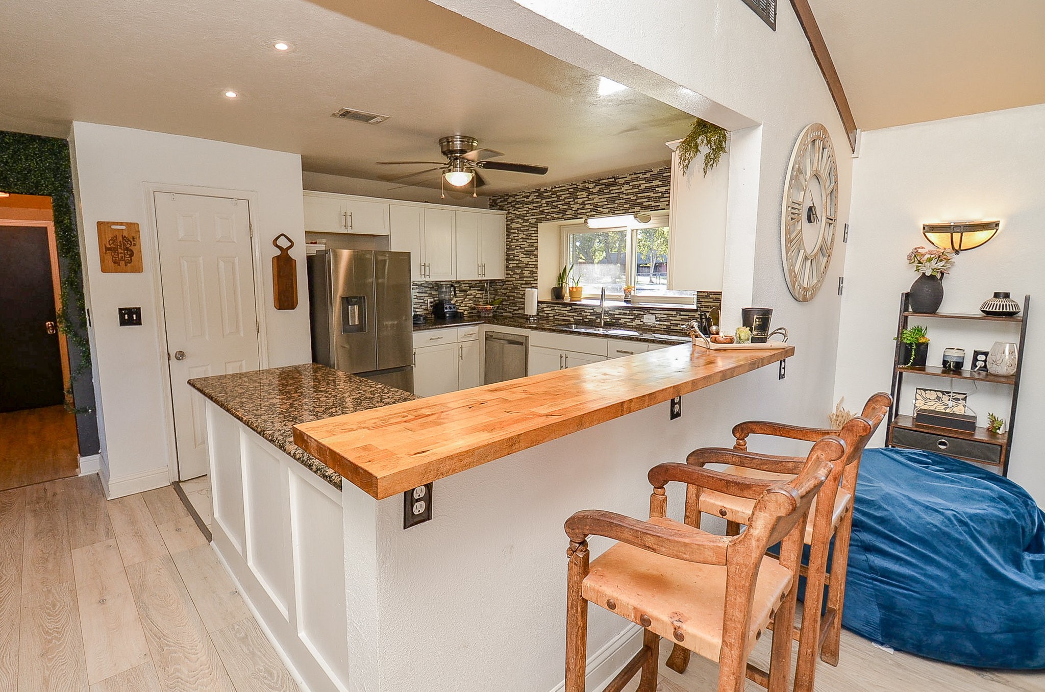 720 Surrey Drive Simonton, TX 77485 - Photo 9 of 34 a kitchen with stainless steel appliances kitchen island granite countertop a table chairs in it and wooden floors