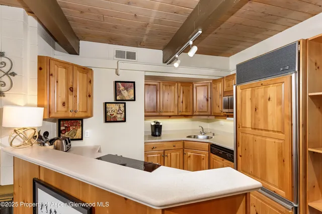 a kitchen that has a sink a microwave and refrigerator