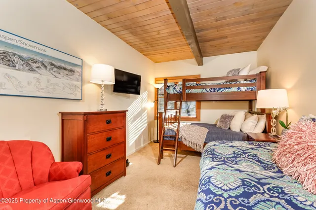 a bedroom with furniture and a flat screen tv