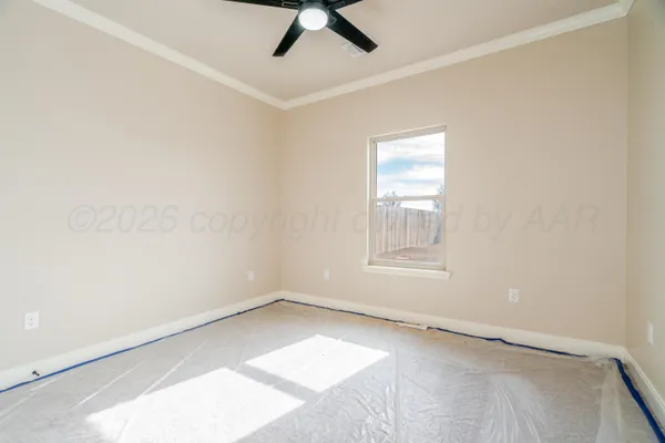 an empty room with ceiling fan and window