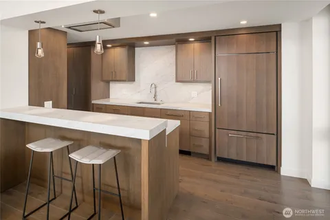 a kitchen with kitchen island a counter top space a sink stainless steel appliances and cabinets