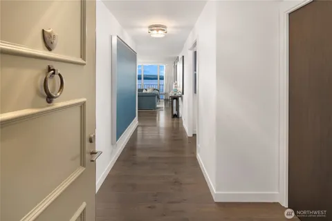 a view of a hallway with a dining table chairs