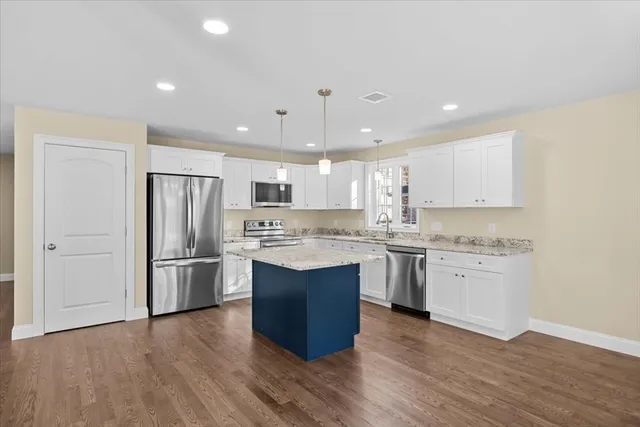 a kitchen with a refrigerator sink and cabinets