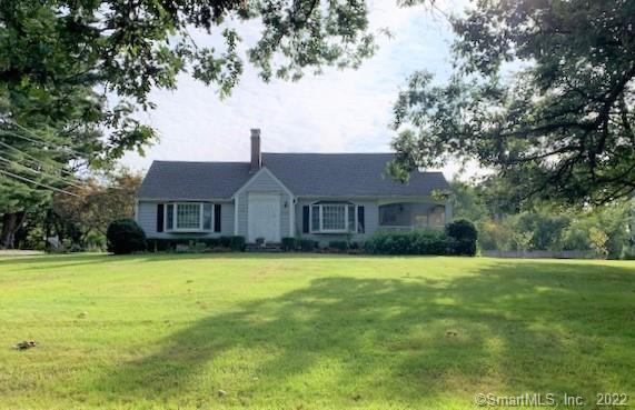 a front view of a house with yard and trees