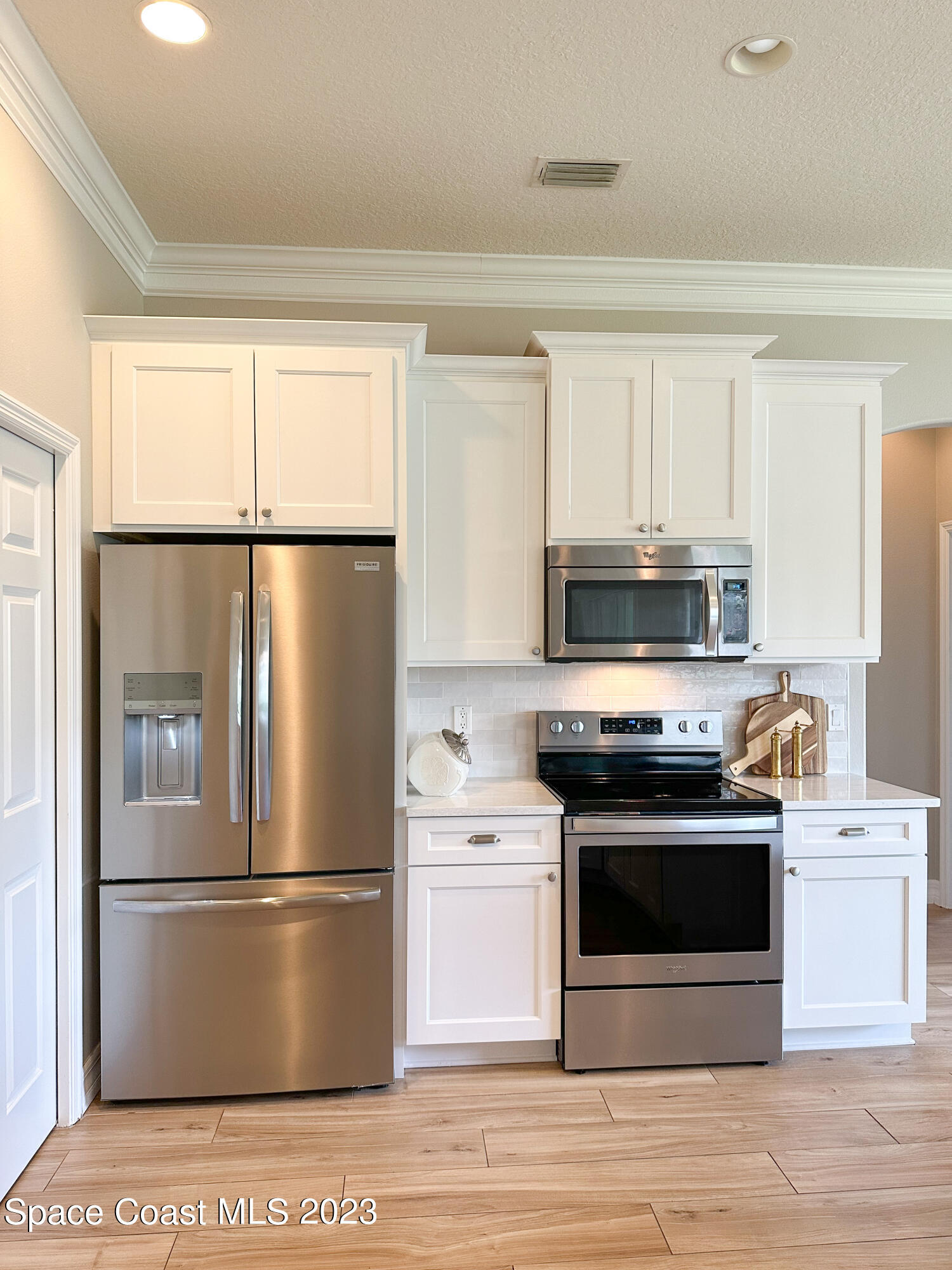 245 Clyde Street Melbourne Beach, FL 32951 - Photo 19 of 88 a kitchen with stainless steel appliances a refrigerator stove and white cabinets