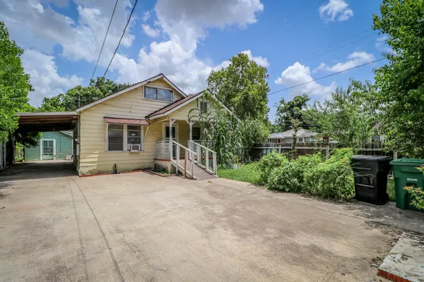 a front view of a house with a yard and potted plants