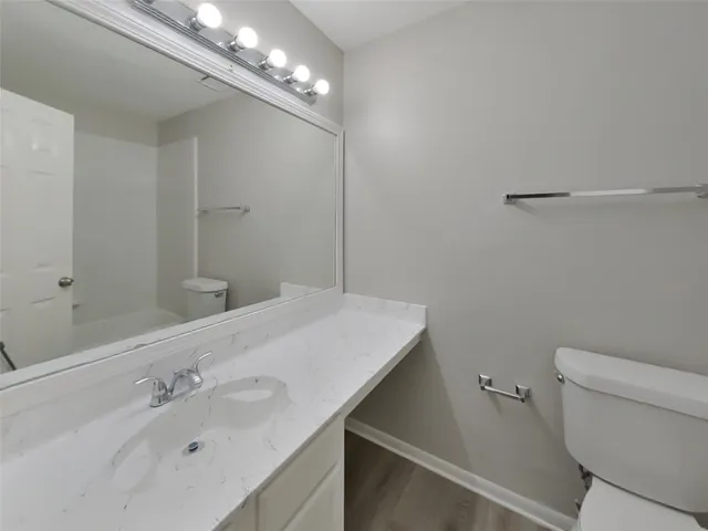 a bathroom with a sink a toilet and a mirror