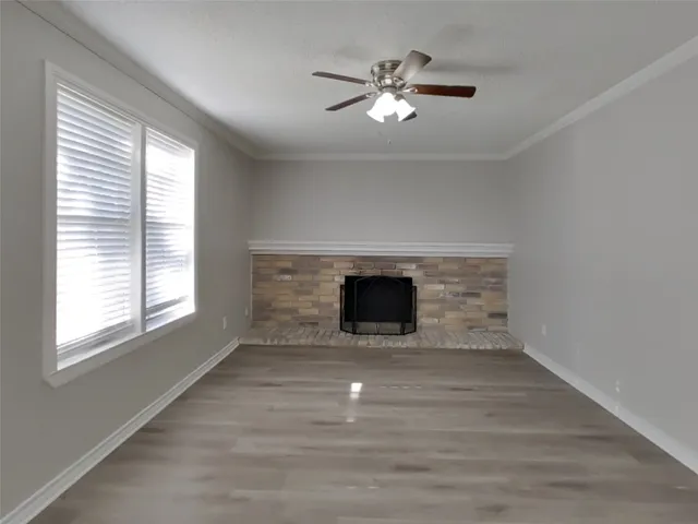 an empty room with windows and fireplace