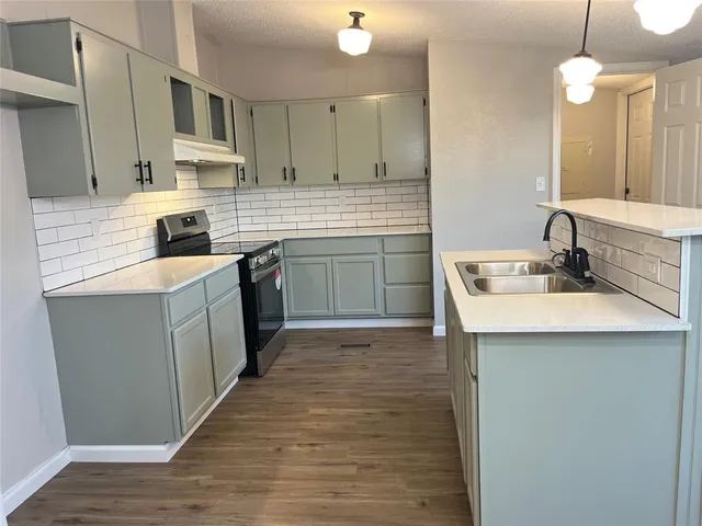 a kitchen with a sink cabinets and wooden floor