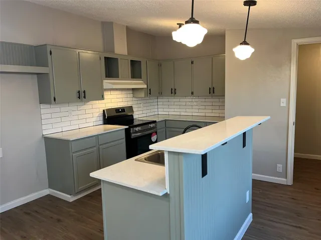 a kitchen with stainless steel appliances kitchen island a cabinets and wooden floor