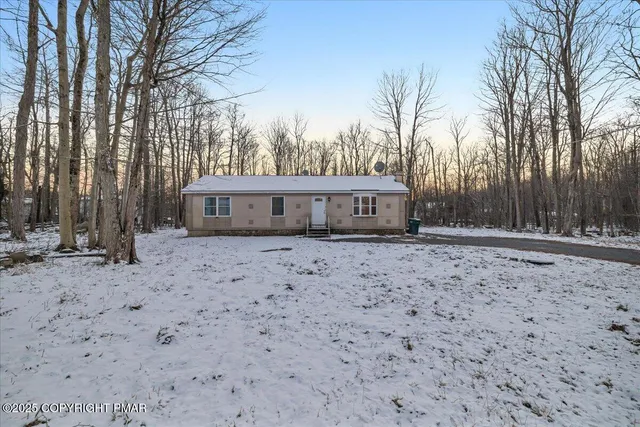 a front view of a house with a yard and trees