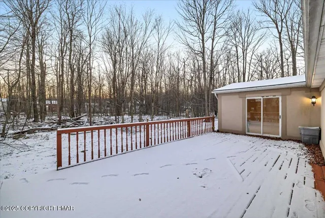 a view of backyard with a deck and wooden fence